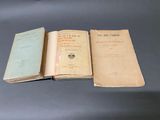 trois vieux livres posés sur une table l'un à côté de l'autre