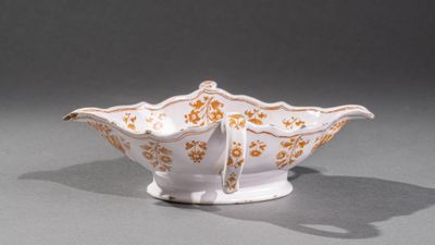 un bol blanc orné de motifs dorés sur un fond gris
