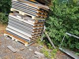 a pile of wood sitting on the side of the road