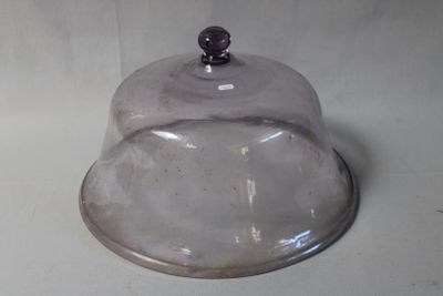 a glass clochet with a metal base on a white surface