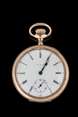 gros plan d'une montre de poche en or sur fond noir