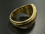 a close up of a gold ring on a black surface