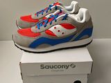 baskets Saucony grises et rouges présentées dans une boîte blanche