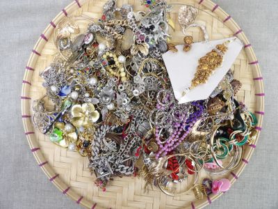 un panier rempli de différents types de bijoux posé sur une table