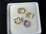 three amethorate gems in a box on a black surface
