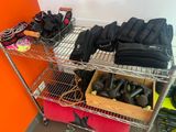 a metal shelf with several pairs of shoes and gloves on it