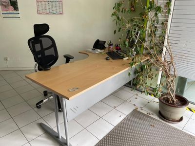 un bureau avec une chaise et une plante en pot posée devant