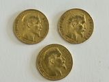 three gold sovereigns, one of which has a head of a man and one of which is a woman