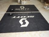 two black mats with white logos on them in a warehouse