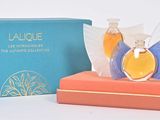 deux flacons de parfum posés sur une boîte, à côté d'une boîte bleue