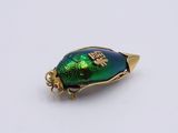 a gold and green beetle charm with a gold plated base