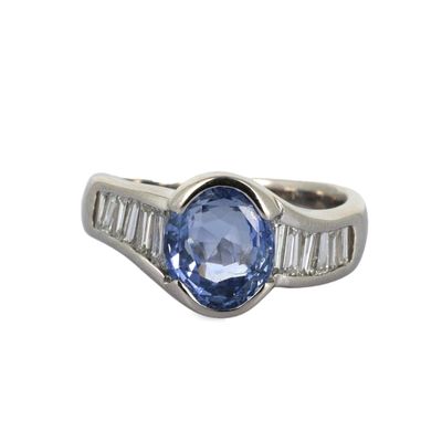 gros plan d'une bague avec un saphir bleu et des diamants