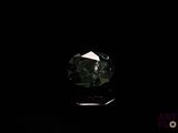 a close up of a green diamond on a black surface