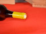 a bottle of wine sitting on a red table cloth