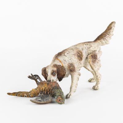 une figurine représentant un chien tenant un faisan dans la gueule