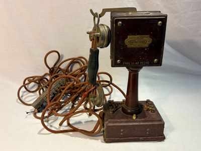 un téléphone à l'ancienne avec un fil qui dépasse par le haut
