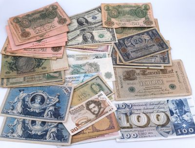 many different types of currency are laid out on a white surface
