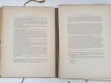 two open books sitting on a table with a string