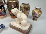 several vases and a statue of a polar bear are on a table