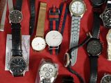 de nombreux modèles de montres exposés sur un tissu rouge