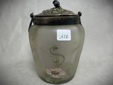 a glass jar with a bird on it on a table