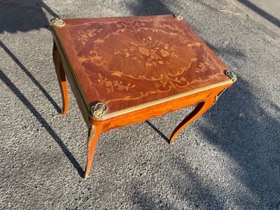 a small wooden table with a floral design on it