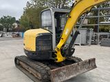 an image of a small excavator parked in a parking lot