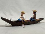 two figurines of a man and a woman in a boat