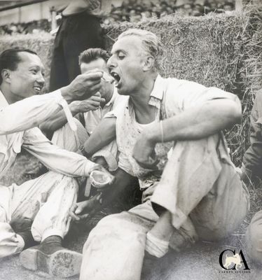 trois hommes assis par terre en train de manger ensemble