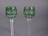 pair of green glass wine glasses on a grey background