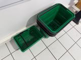 two green baskets sitting next to each other on the floor