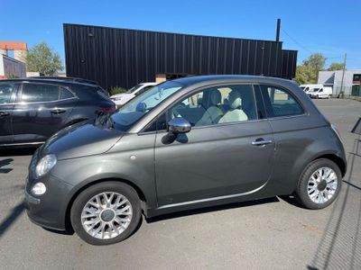the small car is parked in the parking lot next to other cars