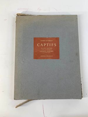 un vieux livre posé sur une table à côté d'une tasse