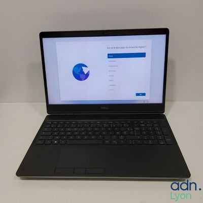 un ordinateur portable ouvert posé sur une table blanche