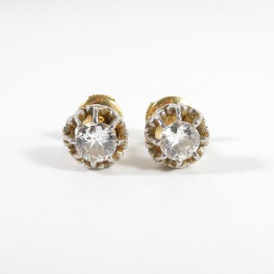 une paire de boucles d'oreilles en or et diamants sur fond blanc