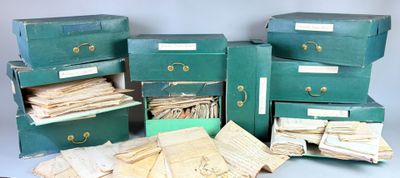 several green boxes with papers and papers are stacked on top of each other