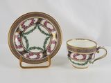 a close up of a cup and saucer on a white surface