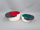 pair of white and black bowls with red and green lids