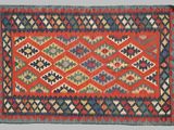 a red, blue, and green rug with a diamond design