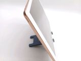 a tablet computer sitting on a stand on a table