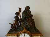 une horloge sur laquelle figurent les statues d'une femme et d'un enfant