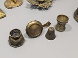 a lot of antique brass objects on a table
