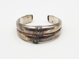 a close up of a silver bracelet on a white surface