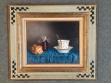 une photo d'un tableau représentant une tasse de thé et un croissant posés sur une nappe bleue