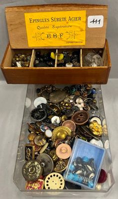 une boîte en bois remplie d'un assortiment de boutons et d'autres objets