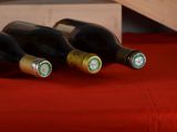 three bottles of wine sitting on a red table