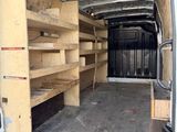 une camionnette blanche équipée d'étagères à l'arrière
