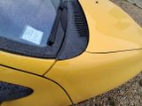 a yellow sports car parked on the side of the road