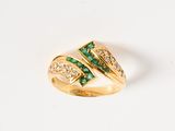 an image of a gold ring with emerald stones and diamonds