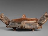 an old wooden bowl with two legs and a handle